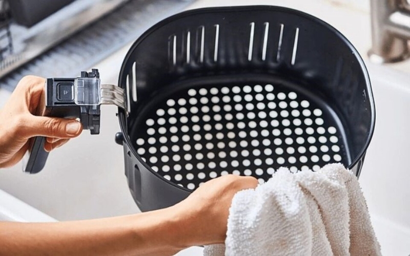 Tháo giỏ chiên và rửa bằng nước ấm với xà phòng