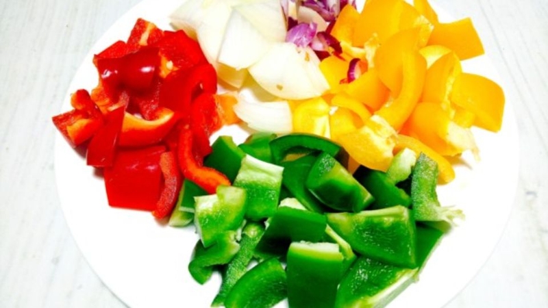 Ớt chuông mua về rửa sạch với nước muối, bỏ cuống và cắt thành những miếng hình thoi đẹp mắt