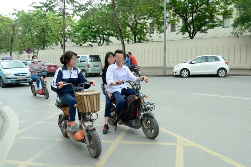 Học sinh đi xe đạp điện không đội mũ bảo hiểm - 02