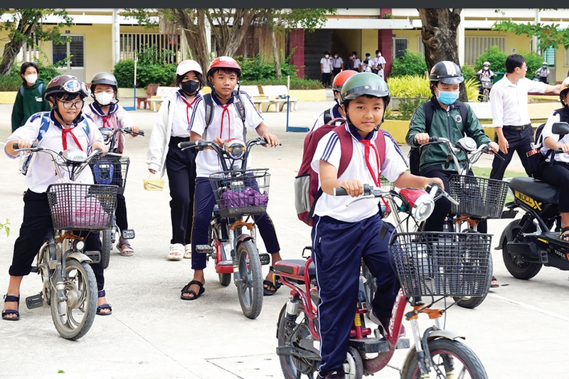 Học sinh đi xe đạp điện không đội mũ bảo hiểm - 05