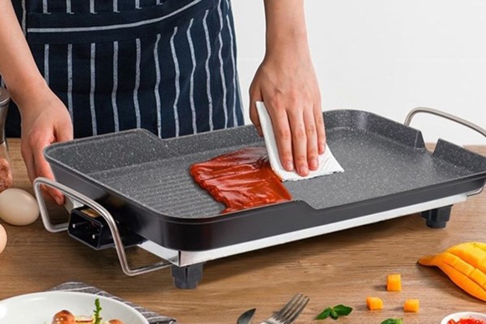 Dùng khăn ướt hoặc bàn chải mềm để làm sạch bề mặt nướng