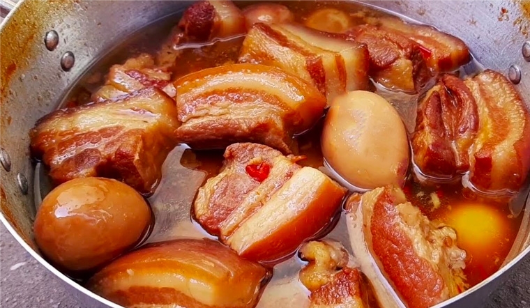 Đun nồi thịt kho trứng trên lửa nhỏ để thịt và trứng ngấm gia vị