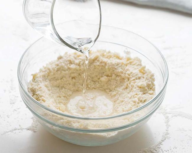 Đổ nước từ từ, nhẹ nhàng vào tô bột