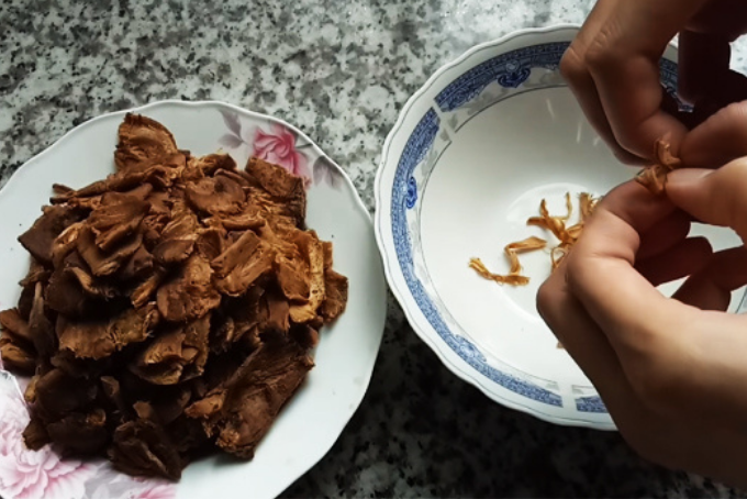 Xé nhỏ nguyên liệu nấm trong cách làm ruốc nấm