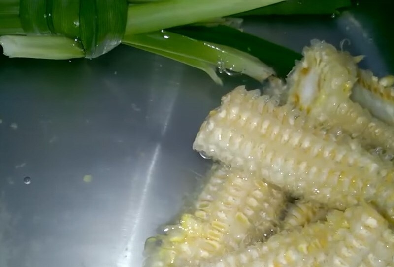 Đun sôi lá dứa và cùi bắp