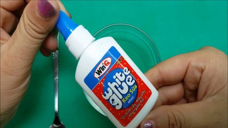 Cho keo sữa vào tô, dùng que từng khuấy kem đánh răng đảo đều hỗn hợp keo sữa