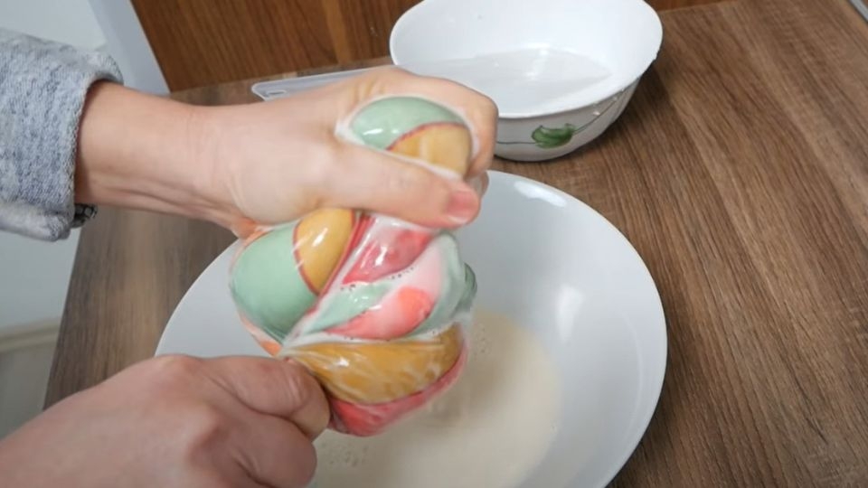 Đặt khoai mì đã bào nhuyễn vào túi vải và vắt thật khô