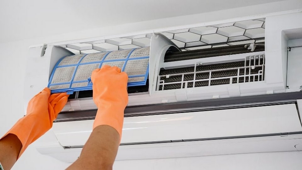 Tháo mặt nạ máy lạnh và thao tác vệ sinh bằng nước.