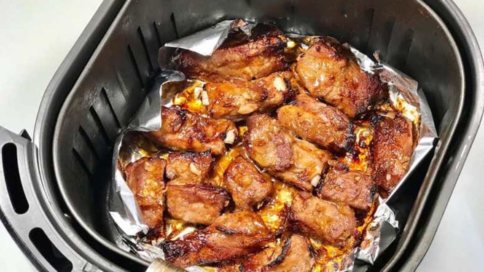 Khi nướng sườn bằng nồi chiên không dầu nên lót giấy bạc để dễ lấy ra và đỡ công cọ nồi