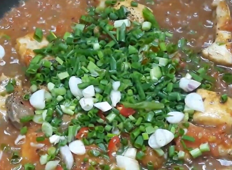 Cho cá, hành lá và ớt vào chảo nước sốt