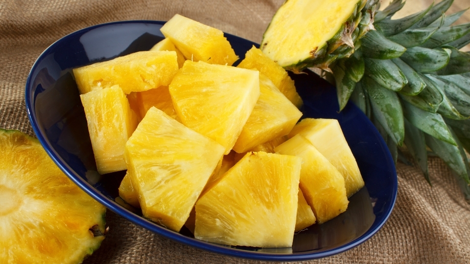 Cắt dứa thành những miếng nhỏ để khi xay được nhuyễn và nhanh hơn