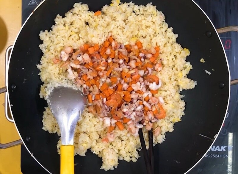 Tiến hành chiên cơm với hỗn hợp rau củ, hải sản