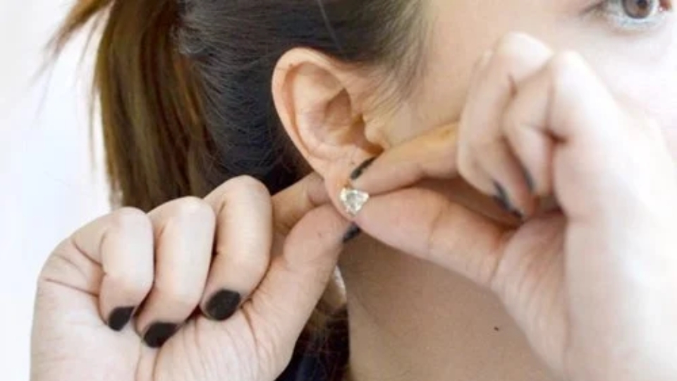 Lắc nhẹ chốt và tiến hành tháo khuyên tai