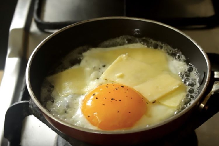 Rắc phô mai lên bề mặt trứng ốp la