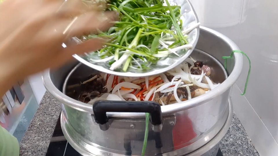 Thêm miến và hành phi, rau mùi, hành lá vào nồi cá chẽm hấp.