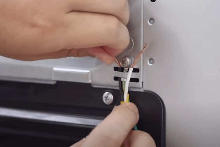 gắn đầu dây điện vào một con ốc vít ở vị trí sau máy giặt