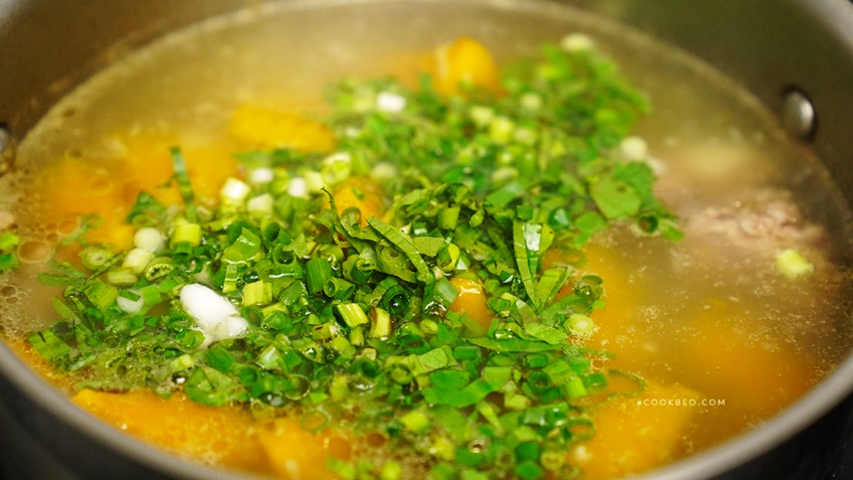 Cho hành lá, mùi tàu vào nồi canh rồi tắt bếp.