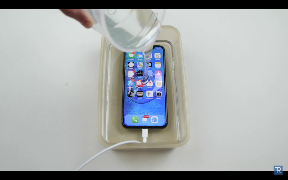 iPhone X bị đặt  trong dung dịch Liquid lỏng.