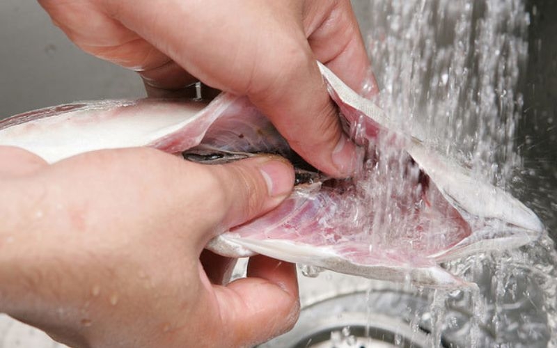 Sơ chế sạch cá trước khi kho