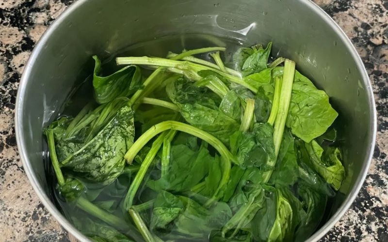 Chần cải bó xôi trước khi xào