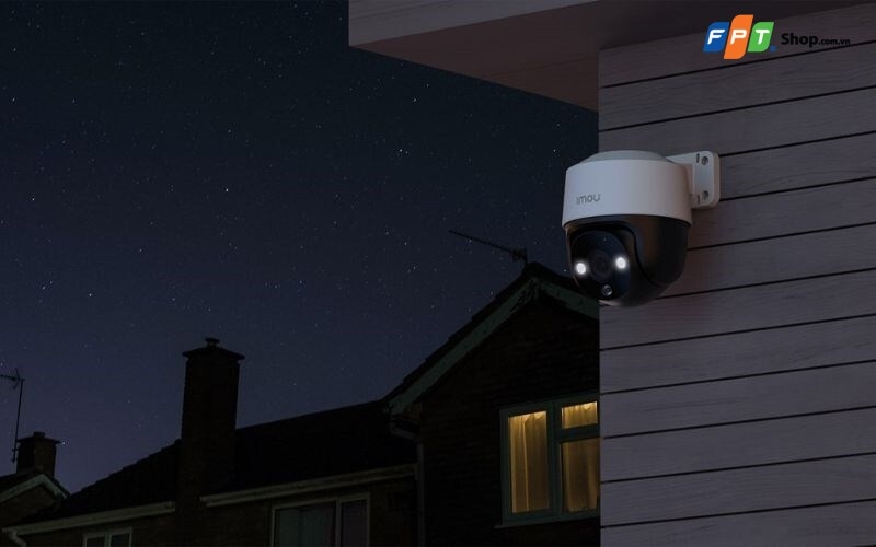 Camera giám sát gắn dưới mái hiên với đèn phía trước sáng trong khung cảnh ban đêm