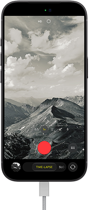 iPhone 18 Pro, vỏ ngoài mặt trước, hiển thị phong cảnh đồi núi, với lớp phủ chế độ camera ở chế độ Tua Nhanh, với cáp nguồn được gắn vào cổng sạc