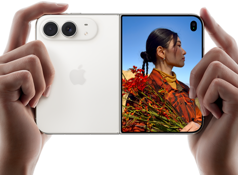 iPhone Duo, màu Trắng Ánh Sao, được cầm bằng hai tay theo hướng ngang, đang mở ra, màn hình bên trái hiển thị camera sau Dual Fusion 48MP, màn hình bên phải hiển thị một người đang chụp ảnh trên màn hình ngoài, chủ thể trong ảnh chụp có thể nhìn thấy khuôn mặt của chính mình khi ảnh được chụp bằng tính năng Duo Preview