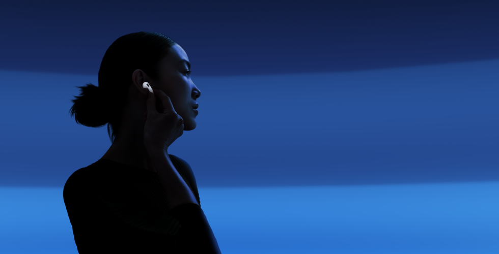 Một người dùng đang dùng ngón cái và ngón trỏ cầm phần thân của AirPods 5 để thay đổi chế độ nghe